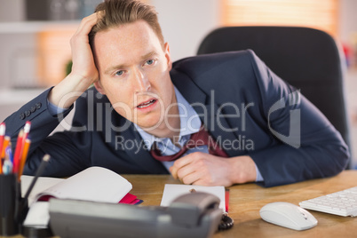 Exhausted businessman working at his desk