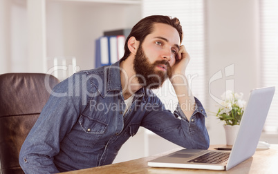 Hipster businessman bored at his desk