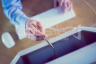 Businessman pointing to screen with pen