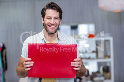 Smiling man holding up red blank sign