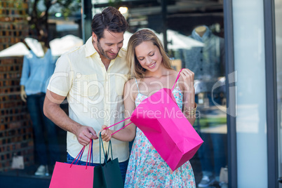 Smiling couple looking into shopping bags