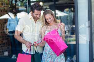 Smiling couple looking into shopping bags