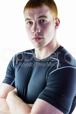 Muscular rugby player with arms crossed