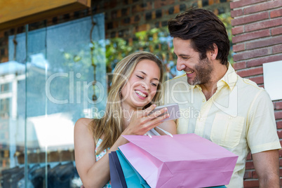 Laughing couple using smartphone Laughing couple using smartphone