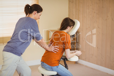 Young woman getting massage in chair