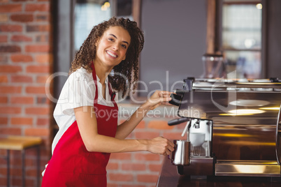 A smiling barista preparing coffee