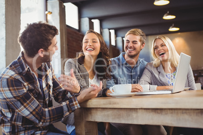 Smiling friends drinking coffee and laughing