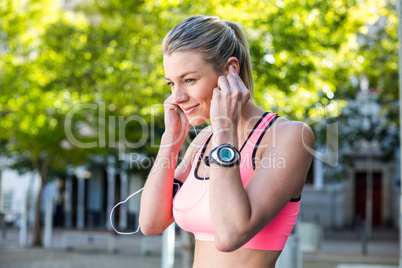 A beautiful athlete putting her headphones