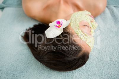 Attractive having green cream on her face at spa center