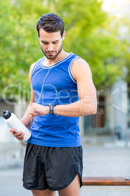 An handsome athlete holding a bottle