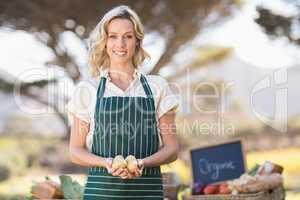 Smiling farmer woman holding potatoes