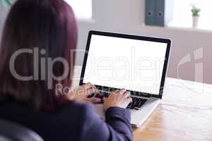 Businesswoman working at her desk on laptop