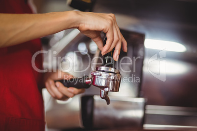 Close up view of a barista pressing coffee