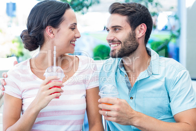 Happy couple drinking milkshakes together