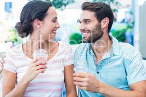 Happy couple drinking milkshakes together