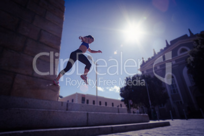 Athletic woman jumping off the stairs