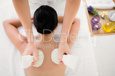 Pretty woman enjoying a herbal compress massage