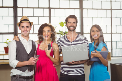 Smiling friends holding different types of multimedia