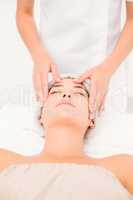 Attractive woman receiving facial massage at spa center