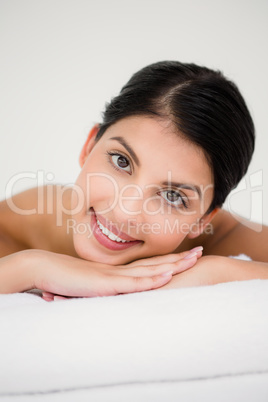 Pretty brunette enjoying a massage smiling at camera