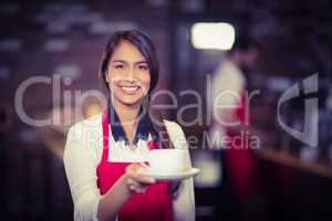 Smiling waitress handing a cup of coffee