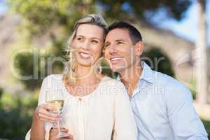 Smiling standing couple enjoying the view and holding wineglass