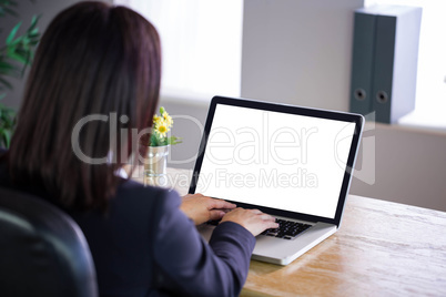 Businesswoman working at her desk on laptop