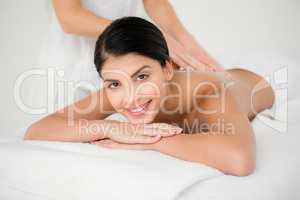 Smiling woman receiving a salt scrub massage