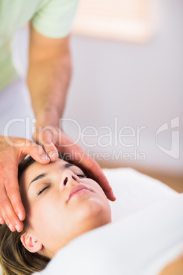 Relaxed pregnant woman getting reiki treatment