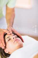 Relaxed pregnant woman getting reiki treatment