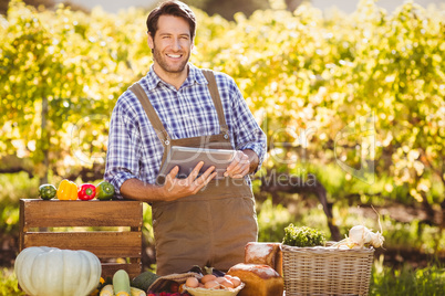 Smiling farmer using a digital tablet