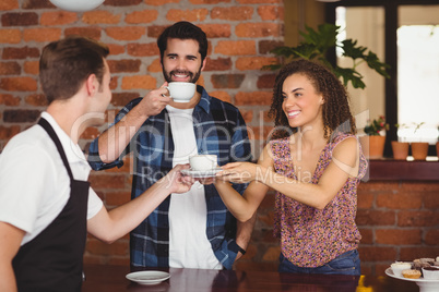 Smiling customers getting cup of coffee