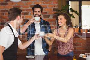 Smiling customers getting cup of coffee