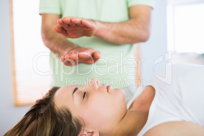 Relaxed pregnant woman getting reiki treatment