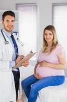 Portrait of smiling doctor and his pregnant patient