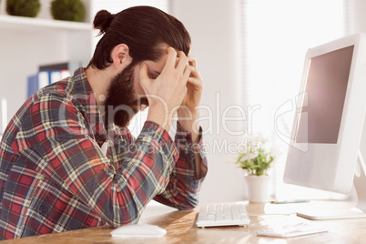 Hipster businessman stressed at his desk