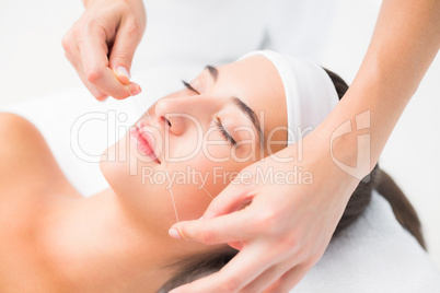 Hands threading beautiful womans upper lip