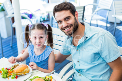 Daughter and father eating at the restaurant