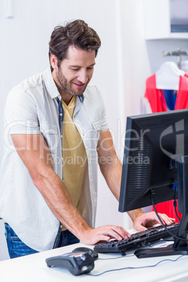 Smiling cashier typing