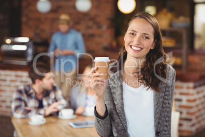 Smiling young woman with take-away cup