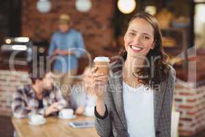 Smiling young woman with take-away cup