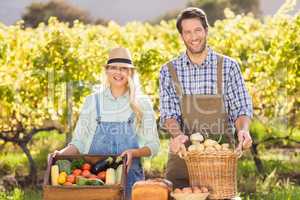 Happy farmer couple presenting their local food