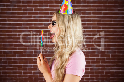 Side view of a beautiful hipster holding a giant lollipop