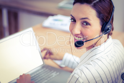 Portrait brunette businesswoman smiling using laptop and headpho