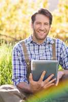 Smiling farmer using a digital tablet