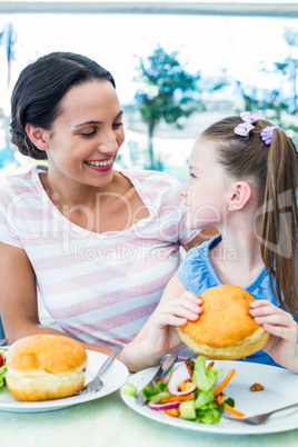 Daughter and mother eating at the restaurant