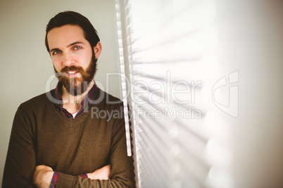 Hipster businessman leaning beside window