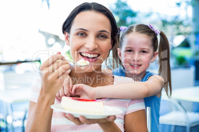 Mother eating a piece of cake with her daughter