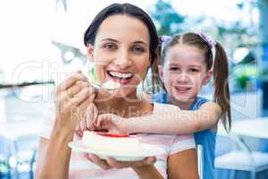 Mother eating a piece of cake with her daughter