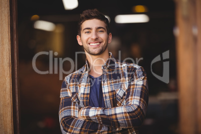 Smiling casual waiter with arms crossed